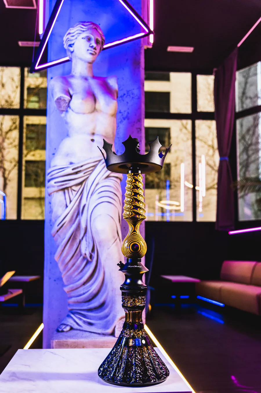 Cachimba Regal Cavalier dorada con corona, delante de una estatua clásica