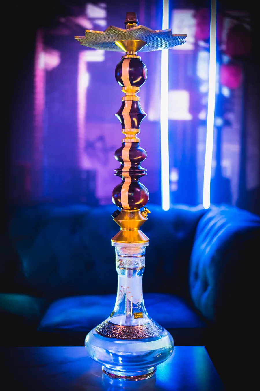 Cachimba Shisha King Bourbon Gold Stripe con corona negra delante de un sofá azul