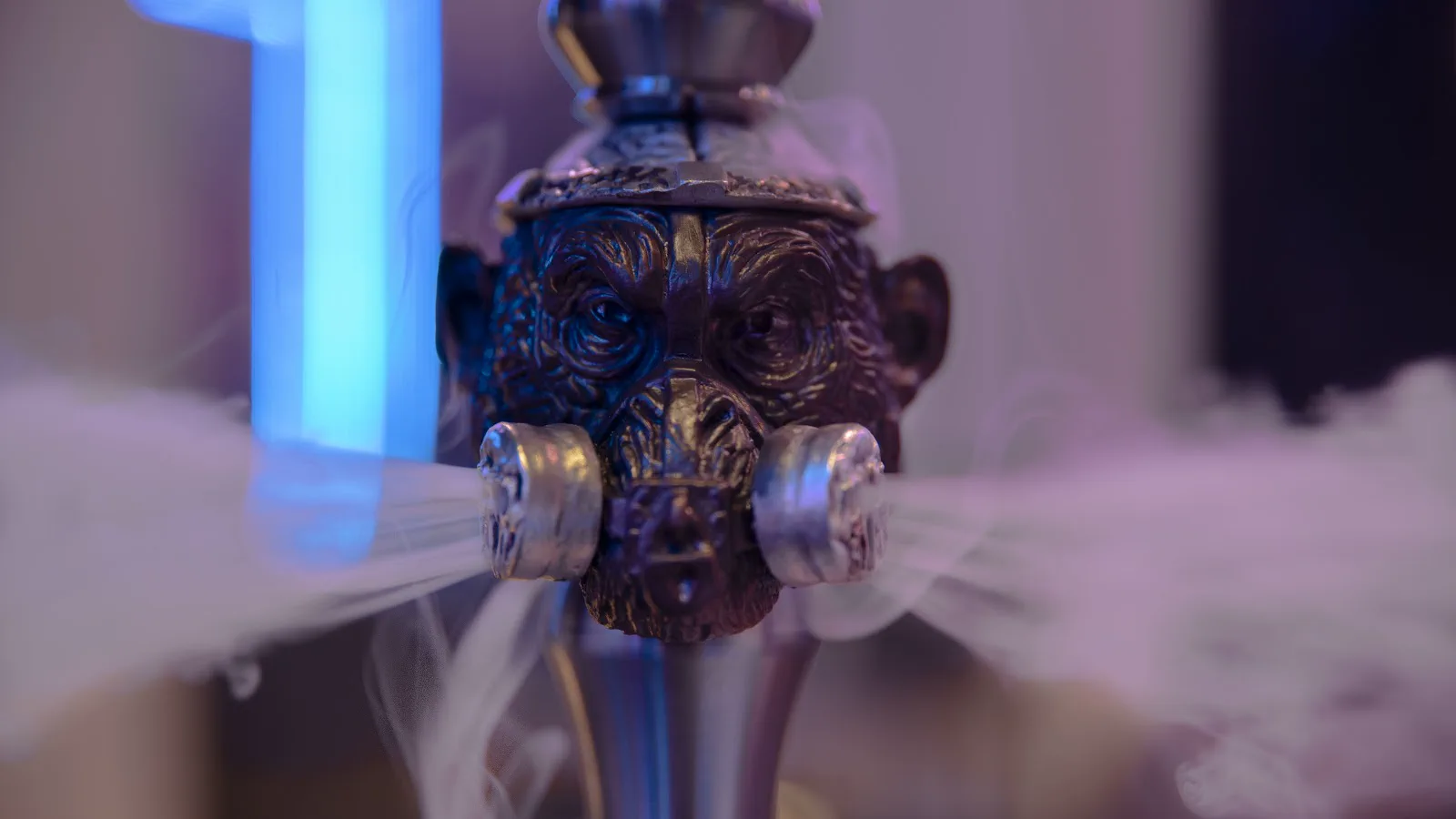 Cachimba con cabeza de mono de metal echando humo por los lados