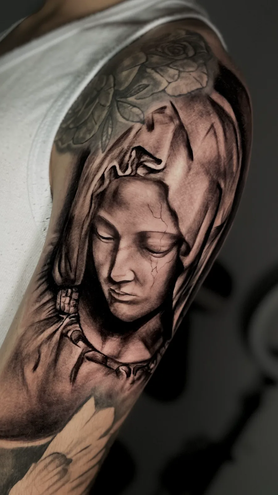 Virgen en realismo tatuada en el brazo